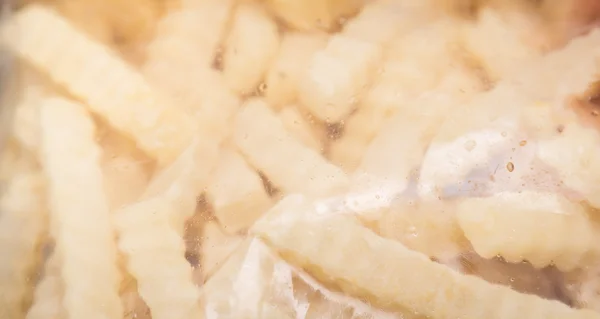 Пакет картошки фри на деревянном фоне — стоковое фото