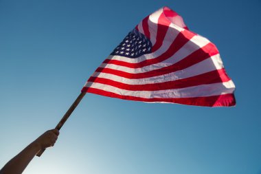 Yıldızlar ve çizgiler ile Amerikan bayrağı ile elini tut