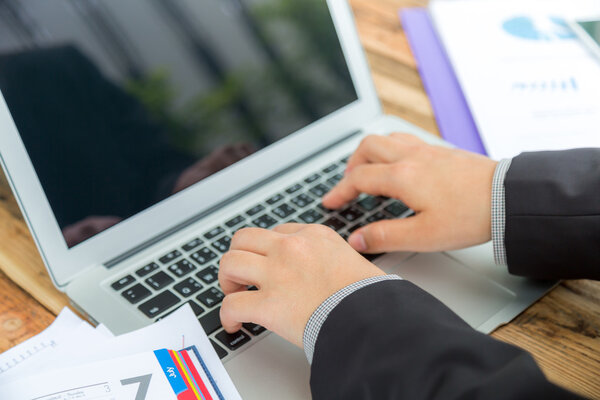 Деловая женщина вручную печатает на клавиатуре ноутбука