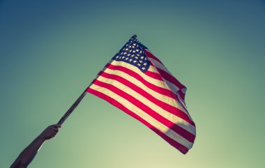 Yıldızlar ve çizgiler ile Amerikan bayrağı blu karşı el ile tutun