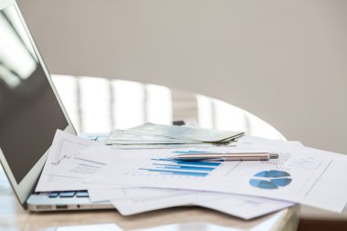 Dizüstü bilgisayar ile masada mali çizelgeleri