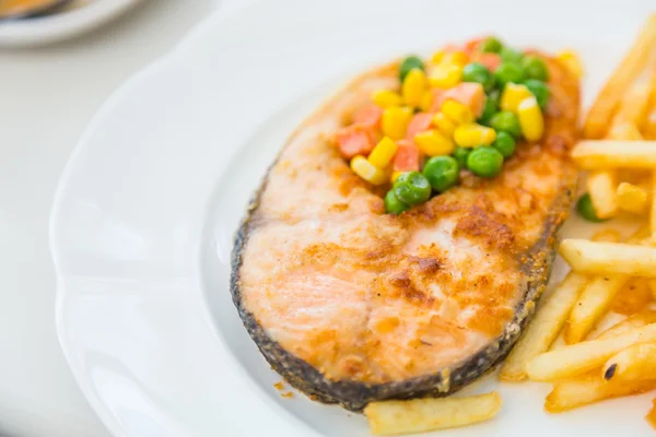 Grilled salmon steak meal served with salad and French fries — Stock Photo, Image