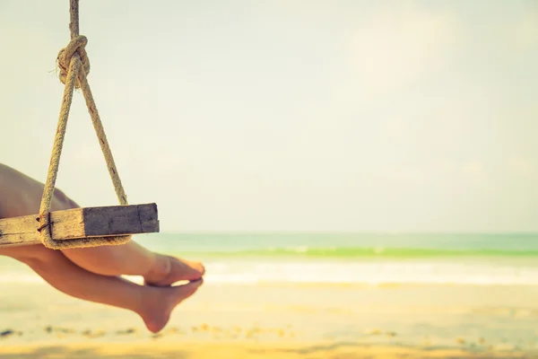 Mujer en un columpio en la playa — Foto de Stock