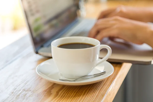 Koffiekopje met laptop op tafel — Stockfoto