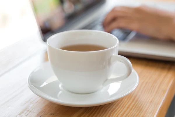 Taza de café con portátil en la mesa — Foto de Stock