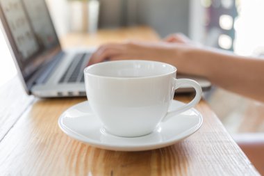 Dizüstü bilgisayar ile kahve fincanı