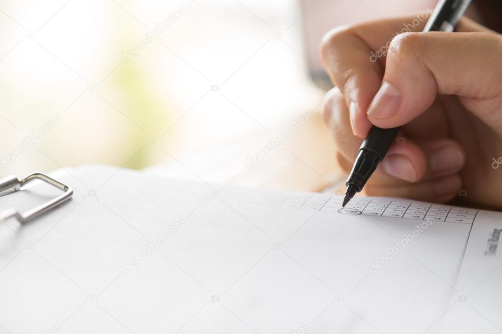 Hand with pen writting on application form