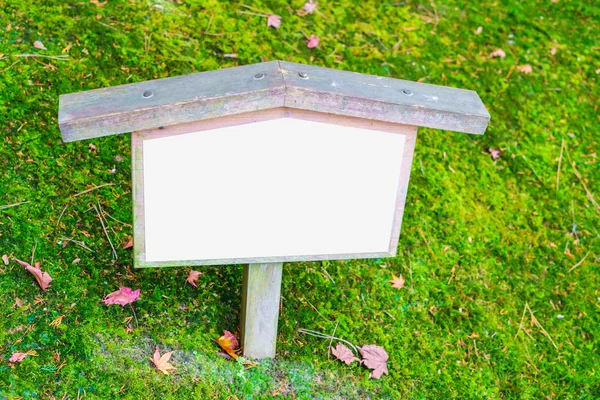 Wooden sign on grass — Stock Photo, Image