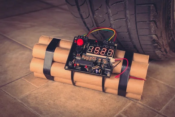 Time bomb near wheel of car — Stock Photo, Image