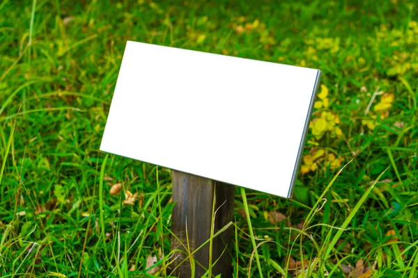 Wooden sign on grass — Stock Photo, Image