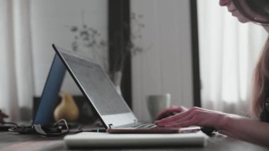 Genç bir adam ve genç bir kız parlak dairelerinde dizüstü bilgisayarların önünde çalışıyorlar. Karantina sırasında evden çalışacağım. Serbest çalışanların uzaktan kumandası. Gözlüklü genç ve güzel bir kız bilgisayar ekranının önünde..