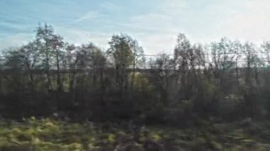 4K 'deki hareket halindeki bir trenin penceresinden bak. Tren penceresinden kırsal alan. Sonbaharda tarlalar ve ormanlar.