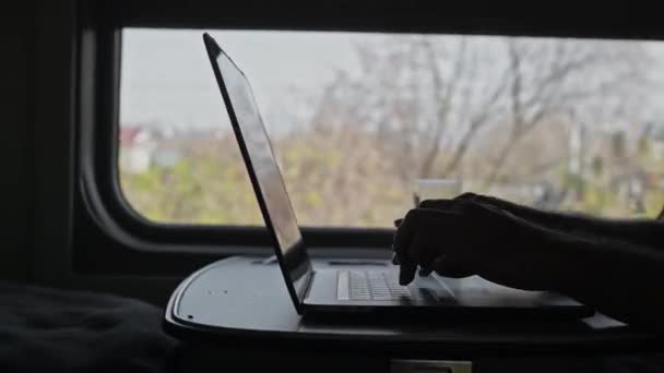 火车上的那个人正在电脑上工作 笔记本电脑键盘上的打印文本 乘火车的自由职业游客 扩大边界 在移动的火车上摇晃 — 图库视频影像