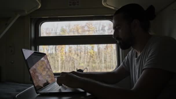 火车上的那个人正在电脑上工作 笔记本电脑键盘上的打印文本 乘火车的自由职业游客 扩大边界 在移动的火车上摇晃 — 图库视频影像