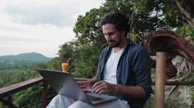 Sakallı, genç, yakışıklı bir adam inanılmaz bir gün batımına bakan bir kafede dizüstü bilgisayarla çalışıyor. Seyahat tutkusu olan serbest çalışan, kafede oturmuş meyve kokteyli yudumlayan..