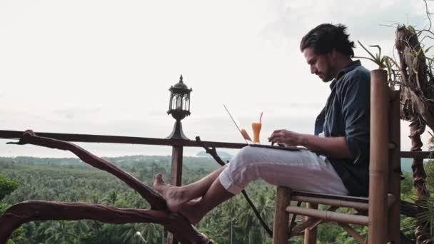 Homem Jovem Bonito Com Barba Trabalha Num Portátil Num Café — Vídeo de Stock