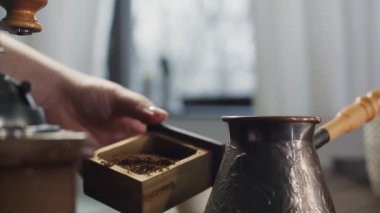 Eski bir değirmende kahve çekirdeklerini öğütme süreci. Bir kadın sabahları kahve hazırlar. Bir Türk 'te taze öğütülmüş aromatik kahve hazırlıyorum..