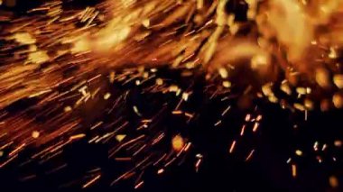 Ağır çekimde, gece gökyüzündeki büyük ateşten kızgın kıvılcımlar yükselir. Ateş, ışık ve yaşam temasının güzel soyut arkaplanı.