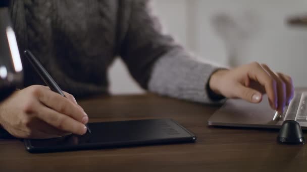 Un joven dibuja en una computadora usando una tableta gráfica. — Vídeos de Stock
