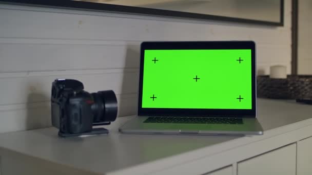 Udsigt til et bord med en bærbar computer med en grøn skærm. – Stock-video