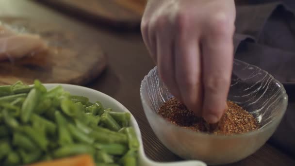 Кухар посипає нарізане куряче м'ясо спеціями . — стокове відео