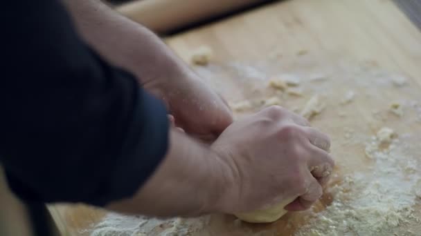 Close-up van een kokshand. Meel wordt verspreid over de tafel. — Stockvideo