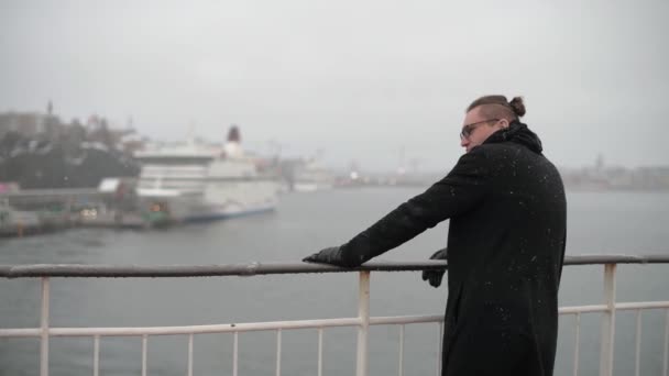 La persona se para en la cubierta trasera del barco y mira el paisaje invernal — Vídeos de Stock