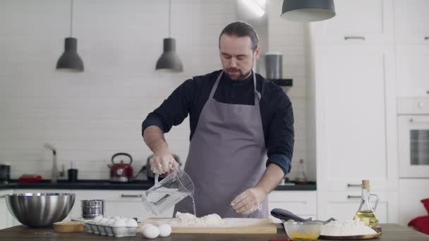 Jonge knappe mannelijke chef-kok bereidt thuis deeg in de keuken. — Stockvideo