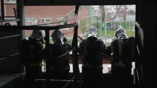 Спасение бессознательного человека на обучении команды профессиональных пожарных. — стоковое видео