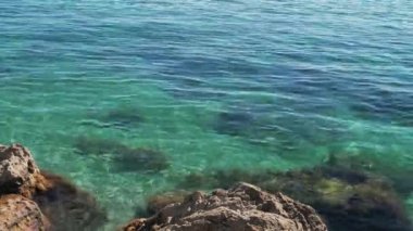 Turistler açık Karadeniz 'de güneşli bir yaz gününde kayaların arasında yüzerler..