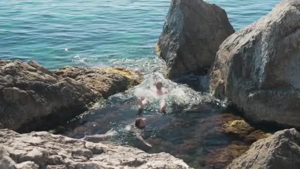 Οι τουρίστες κολυμπούν στην ανοικτή Μαύρη Θάλασσα ανάμεσα στα βράχια σε μια σαφή ηλιόλουστη μέρα του καλοκαιριού. — Αρχείο Βίντεο