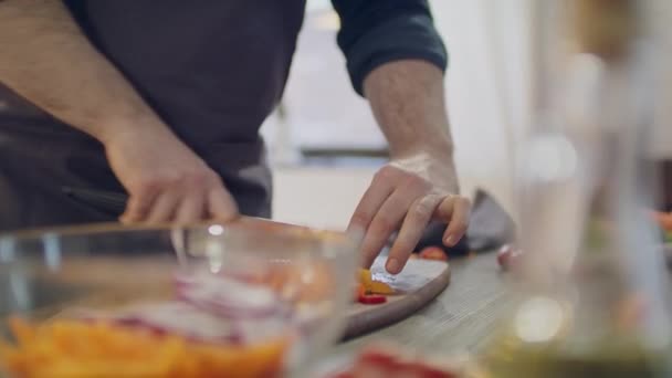 Verse groenten op tafel. Een jongeman bereidt eten in de keuken. — Stockvideo