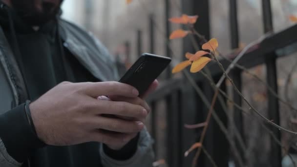 Primo piano di uno smartphone nelle mani di un giovane. — Video Stock