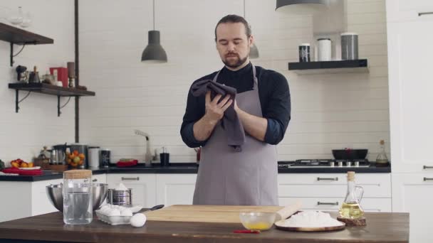 El chef del delantal amasa la masa. Cocina blanca durante el día. — Vídeos de Stock