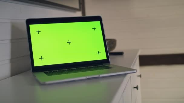 View of a table with a laptop computer with a green screen. — Stock Video