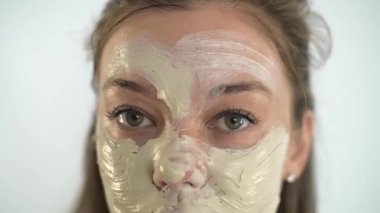 Genç ve güzel bir kız yüzüne nemlendirici bir maske takıyor.