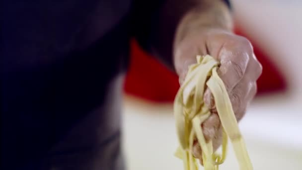 De chef snijdt de spaghetti. Close-up van pastadeeg — Stockvideo