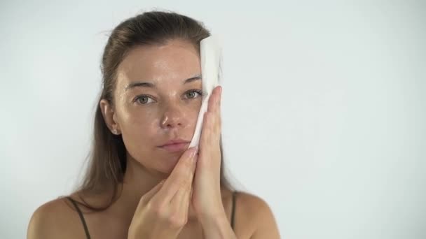 Het meisje verwijdert het masker van haar gezicht met een spons. Cosmetologische procedure. — Stockvideo