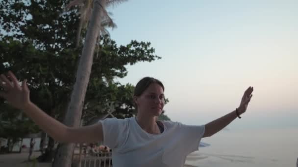 Dziewczyna idzie na slackline o zachodzie słońca na tropikalnej plaży. — Wideo stockowe