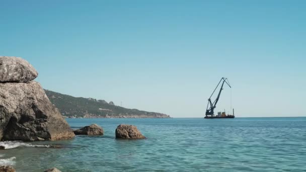 En oljerigg står i havet bredvid stranden. — Stockvideo