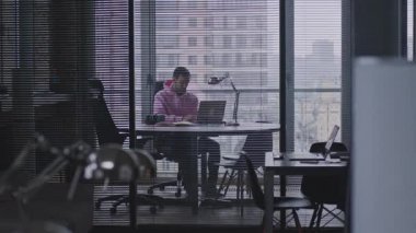 Genç, yakışıklı bir adam çalışma odasında çalışıyor..