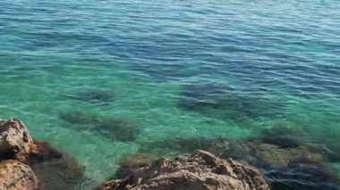 Turistler açık Karadeniz 'de güneşli bir yaz gününde kayaların arasında yüzerler..