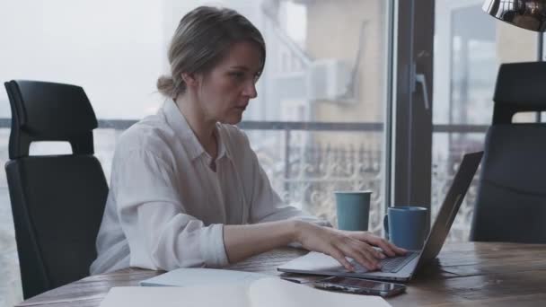 Junge Frau arbeitet für einen Laptop im Büro für die geschäftliche Korrespondenz. — Stockvideo