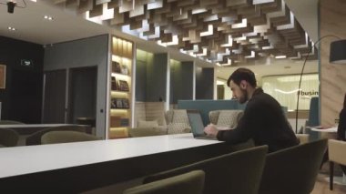 Genç odaklı yakışıklı iş adamı dizüstü bilgisayarla çalışıyor..