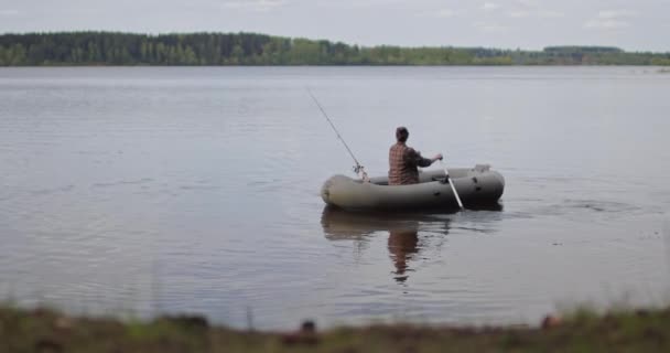 美しい映画撮影だ。湖の上に女の子漁師漕ぎオアーズインフレータブルボート. — ストック動画