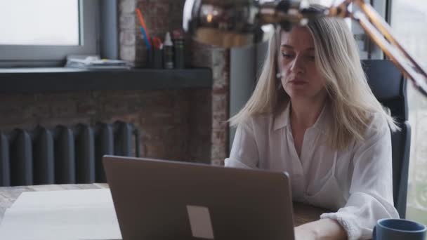 Молода жінка працює на ноутбук в офісі робить ділове листування . — стокове відео
