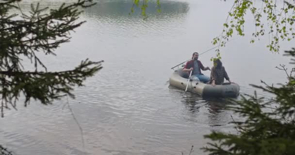 Tinerii pescari de pe o barcă gonflabilă de pe lac pescuiesc. Fotografie cinematografică. — Videoclip de stoc