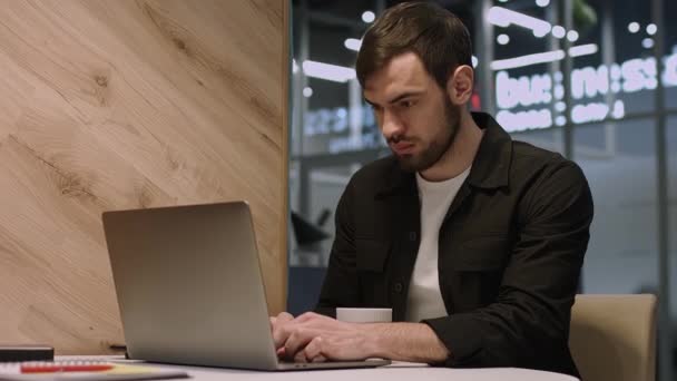 在笔记本电脑上工作的年轻而专注的英俊男性商人. — 图库视频影像