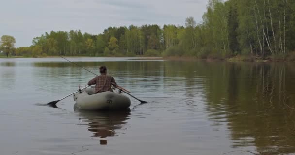 Hermoso rodaje cinematográfico. Niña pescador remo remos en el lago un bote inflable. — Vídeos de Stock