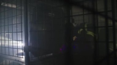 Bir itfaiyeci dumanlı bir odada, karanlıkta fenerle sürünür..